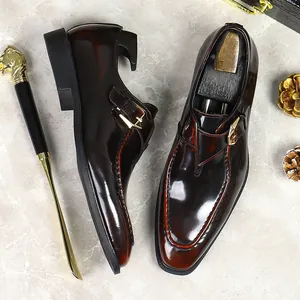 Polished burgundy leather monk strap shoes with gold buckle and elegant wood shoe trees