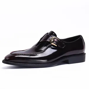 Polished dark reddish-brown monk strap leather shoes with a gold buckle on white background