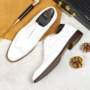 White leather men's Brogue Oxford shoes with brown wooden soles in a luxury setting