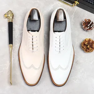 Classic men's wingtip brogue oxfords in beige and white leather with elegant hole detailing