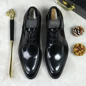Formal black patent leather men's dress shoes with pointed toe and U-stitch detail