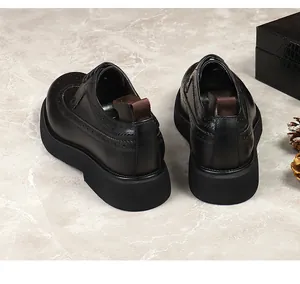 Λεπτομέρεια μαύρα δερμάτινα παπούτσια brogue με χοντρές σόλες και θηλιές στη φτέρνα