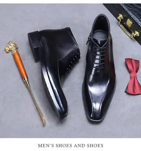 Détail de bottines en cuir noir brillant avec fermeture éclair latérale et lacets