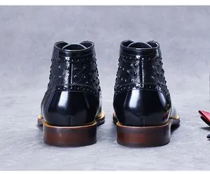 Rear view of black patent leather boots featuring ostrich texture and brogue details