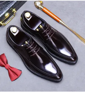 Vista dall'alto di scarpe derby in pelle rosso scuro con accessori eleganti da uomo