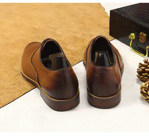 Detail brauner Leder-Derbyschuhe mit Brogue-Lochungen und geprägter Webstruktur am Fersenteil