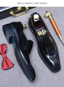 Vista dall'alto di scarpe eleganti in pelle nera lucida con accessori business