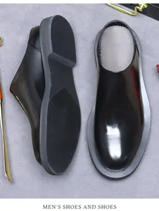 Overhead view of men's glossy black leather mules with non-slip rubber soles