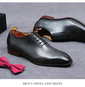 Detail van zwarte lederen oxfordschoenen met lasergegraveerde neus en houten schoenspanners