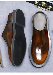 Macro view of brown gradient glossy leather mule shoes with non-slip thick rubber soles