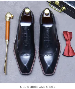 Nahaufnahme schwarzer Oxford-Schuhe aus Leder mit Brogue-Verzierung und Dress-Accessoires