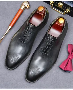 Detail van zwarte Oxford lederen schoenen met reliëfpatroon en luxe klassieke accessoires