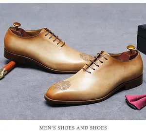 Detail van handgepoetste bruine leren brogues met barokke bloemengravure voor heren