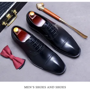 Close-up of black leather oxford shoes with brogue details, shoe horn, and accessories