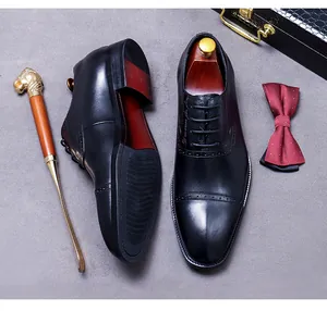 Top view of premium black leather oxford shoes with brogue details and shoe horn