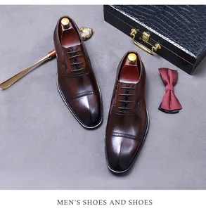 Close-up of brown leather Oxford shoes with brogue detailing and formal accessories