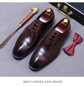 Flat lay of brown leather Oxford shoes with brogue detailing and formal accessories