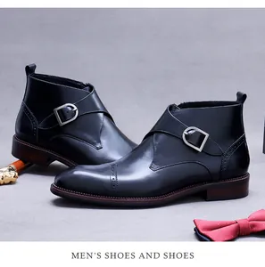 Detail of black leather monk strap boots with brogue carvings and premium silver buckles