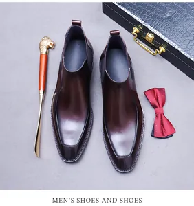 Draufsicht auf glänzende dunkelbraune Leder Chelsea Boots mit Luxus-Business-Accessoires