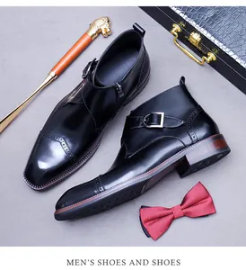 Detail of black leather monk strap boots with brogue carving and inner zipper