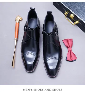 Detail of black leather monk strap shoe with brogue patterns and metal shoe horn