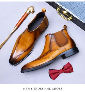 Gros plan de bottines Chelsea en cuir dégradé marron avec accessoires de mode pour hommes