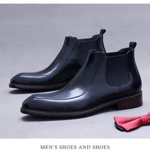 Detail eines Chelsea-Boots aus schwarzem Leder mit elastischer Seite und brauner Sohle