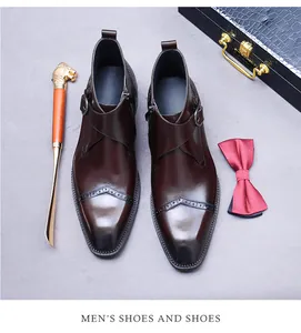Detail shot of men's oxblood brogue boots with buckle strap and side zipper finish