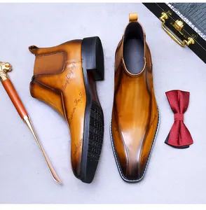 Gros plan de bottines Chelsea en cuir marron avec écriture décorative et bout pointu