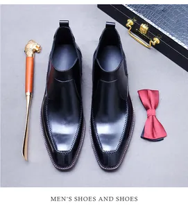 Dettaglio di scarpe brogue in pelle nera con calzante a testa di leone e papillon