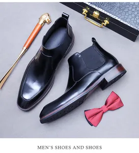 Dettaglio stivaletti Chelsea in pelle nera con intagli Brogue e accessori in stile inglese