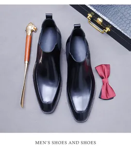 Flachbild von schwarzen Chelsea-Boots aus Leder mit Schuhanzieher und Fliege-Detail