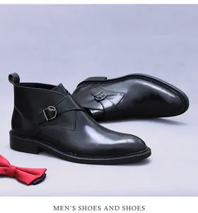 Detail of black leather boots featuring cursive texture and metallic monk strap buckle