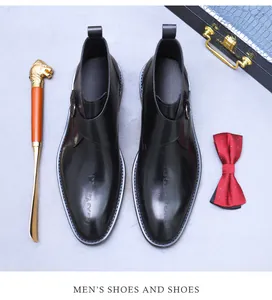 Detail of black leather monk strap shoe with artistic lettering and metallic buckle