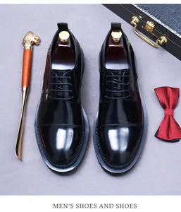Chaussures richelieu en cuir noir poli avec bout rapporté sur fond gris et accessoires