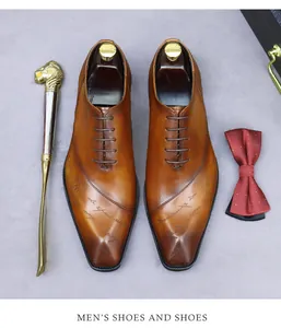 Close-up of brown leather dress shoes featuring script design, lion shoehorn, and bowtie