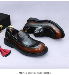 Detail van gepolijste bruine penny loafers met dikke zool en zijden vlinderdas ernaast