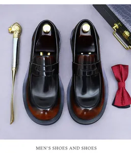 Bovenaanzicht van bruine leren loafers met schoenspanners en accessoires in geschenkdoos