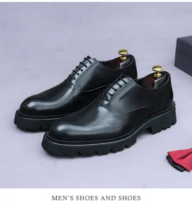 Detail von schwarzen Brogue-Herrenschuhen aus Leder mit klassischer Lochverzierung