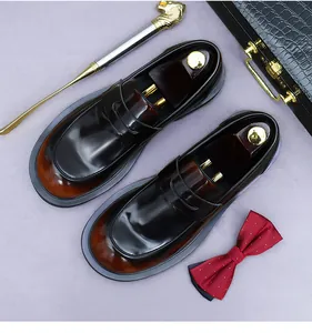 Detail van leren herenloafers met kleurverloop en leeuwenkop schoenlepel
