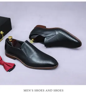 Macro shot of men's black perforated leather business loafers with stylish brown sole