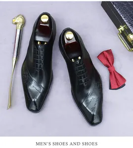 Detail of premium black leather dress shoes with artistic letter embossing and accessories