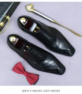 Detail of black leather oxford shoe with embossed logo and elegant紳士 props