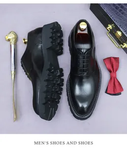 Nahaufnahme schwarzer Brogue-Lederschuhe mit dicker Profilsohle und edlen Accessoires
