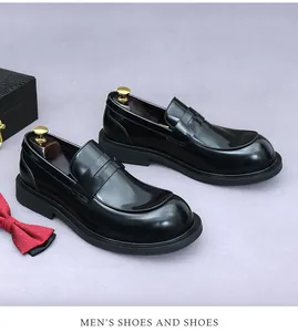Gepolijste zwarte leren loafers met houten schoenspanner en rode vlinderdas
