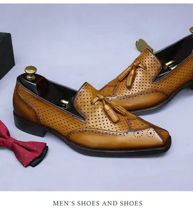 Dettaglio macro di mocassini in pelle marrone con trafori brogue ed eleganti nappe