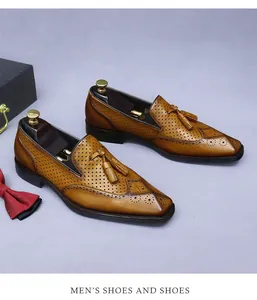 Dettaglio di scarpe brogue in pelle marrone con fori traspiranti e nappe eleganti