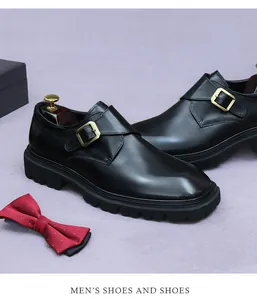 Detail van zwarte monk strap herenschoen met gouden gesp en robuuste rubberen profielzool