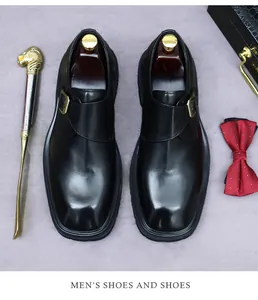 Bovenaanzicht van zwarte lederen monk strap schoenen met schoenspanners en gouden schoenlepel