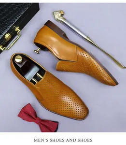 Close-up of brown leather slip-on shoes with laser-cut perforations and accessories